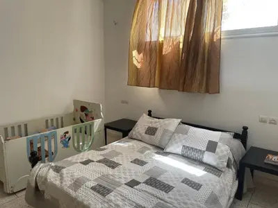 a bedroom with a bed and a crib in it at Appartement 2 chambres avec lit bébé in Fès