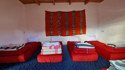 a room with two red couches and a window at Gite taouraout in Midelt