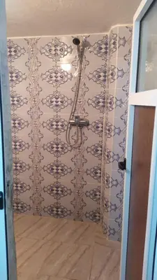 a bathroom with a shower with blue and white tiles at Gite taouraout in Midelt