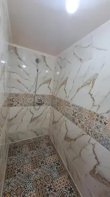 a bathroom with a shower and a tile floor at Gite taouraout in Midelt