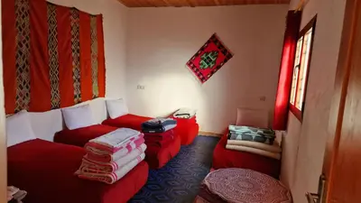a living room with two red couches and a window at Gite taouraout in Midelt