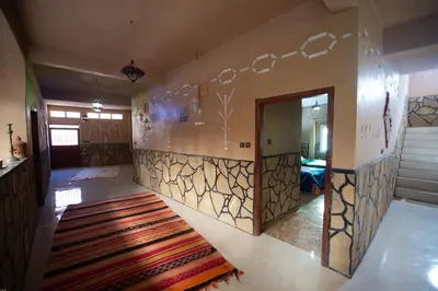 a room with a hallway with a door and a rug at Riad Lalla in Tinerhir