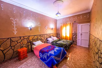 a bedroom with two beds in a room at Riad Lalla in Tinerhir