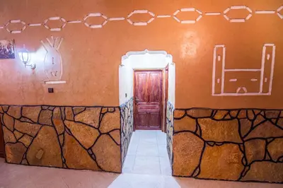 a room with a door and a stone wall at Riad Lalla in Tinerhir