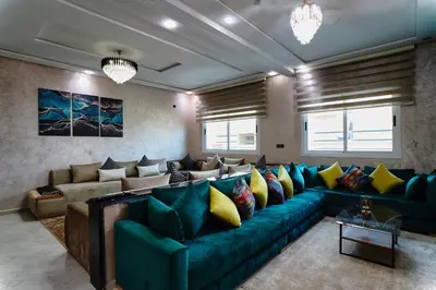 a living room with a green couch and yellow pillows at Appartement Emeraude - Calme, Moderne & Sécurisé in Fès