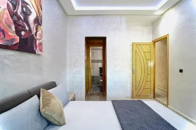 a bedroom with a bed and a painting on the wall at Appartement Emeraude - Calme, Moderne & Sécurisé in Fès
