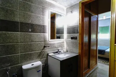 a bathroom with a sink and a toilet and a mirror at Appartement Emeraude - Calme, Moderne & Sécurisé in Fès