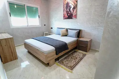 a bedroom with a bed in a room with a window at Appartement Emeraude - Calme, Moderne & Sécurisé in Fès