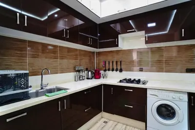 a kitchen with a sink and a washing machine at Appartement Emeraude - Calme, Moderne & Sécurisé in Fès