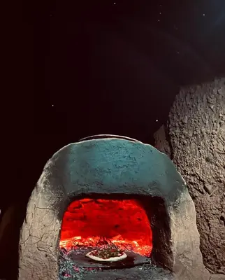 a stone oven with a pizza inside of it at Dar Nomad Tagounite in Zagora