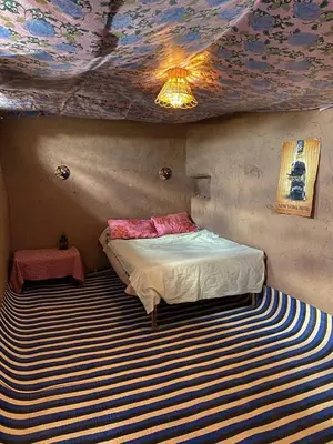 a bedroom with a bed with a painted ceiling at Dar Nomad Tagounite in Zagora