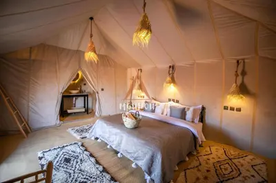 a bedroom with a bed in a tent at Mouhou Desert Camp in Merzouga