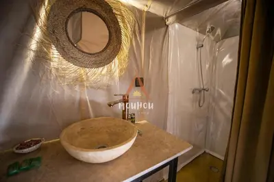 a bathroom with a large sink and a shower at Mouhou Desert Camp in Merzouga
