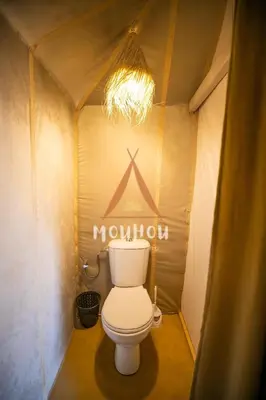 a toilet in a small bathroom with a chandelier at Mouhou Desert Camp in Merzouga