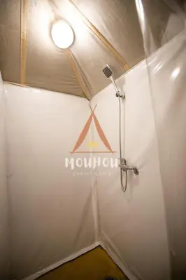 a white tent with a sign on the wall at Mouhou Desert Camp in Merzouga