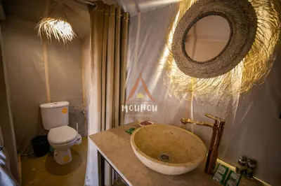 a bathroom with a sink and a toilet and a mirror at Mouhou Desert Camp in Merzouga