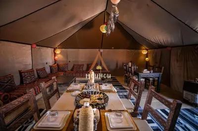 a dining room with a table in a tent at Mouhou Desert Camp in Merzouga