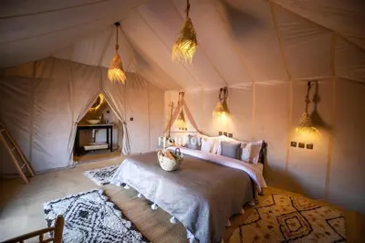 a bedroom with a bed in a tent at Mouhou Desert Camp in Merzouga