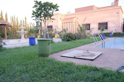 a yard with a pool and a fountain and a bucket at Villa world Marrakech in Marrakech