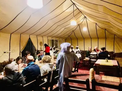 a group of people sitting in a tent at Erg Chebbi Desert Luxury Camp in Merzouga