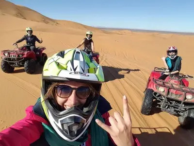 a group of people riding on atvs in the desert at Erg Chebbi Desert Luxury Camp in Merzouga