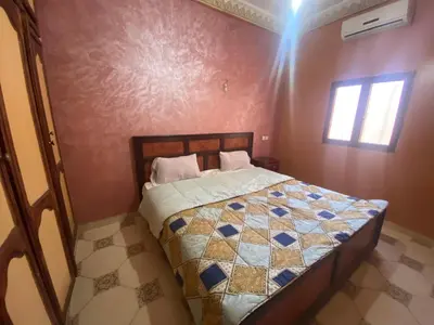 a bedroom with a bed in the corner of a room at Apartement Rachid in Merzouga