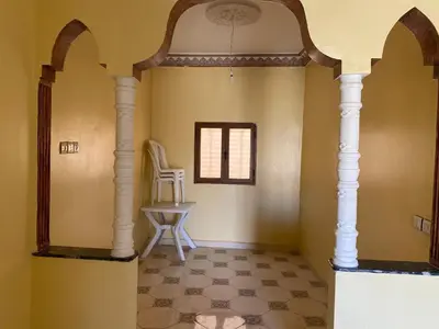 a hallway with a table and a chair in a room at Apartement Rachid in Merzouga