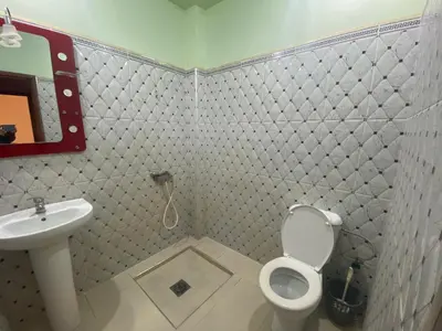a bathroom with a white toilet and a sink at Apartement Rachid in Merzouga