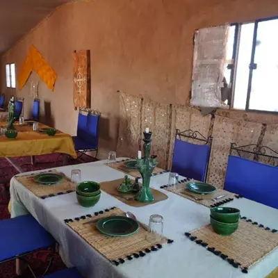 a room with a table with green dishes on it at Chegaga Desert Trips in Mhamid