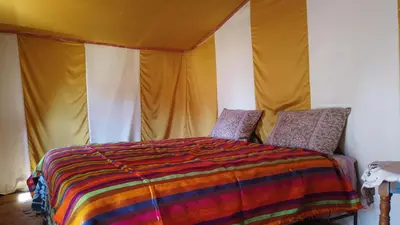a bedroom with a bed in a tent at Chegaga Desert Trips in Mhamid