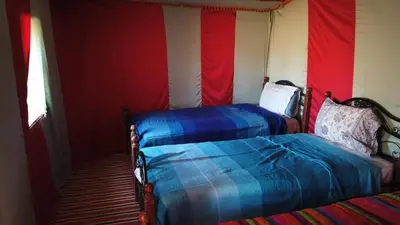 two beds in a room with red and blue at Chegaga Desert Trips in Mhamid
