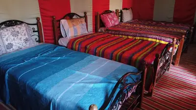 two beds sitting next to each other in a room at Chegaga Desert Trips in Mhamid