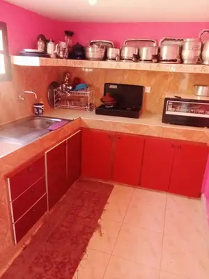 a kitchen with red cabinets and a sink at Gite entre les Vallées in Tacheddirt