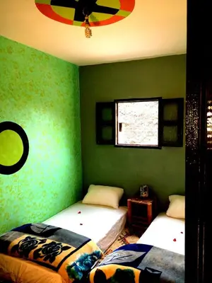 two beds in a room with green walls at Gite entre les Vallées in Tacheddirt