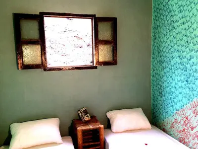 a room with two beds and a window at Gite entre les Vallées in Tacheddirt