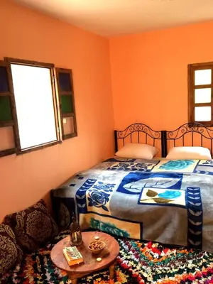 a bedroom with a bed and a table and a window at Gite entre les Vallées in Tacheddirt