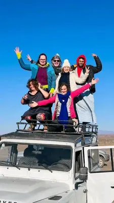 a group of people standing on top of a vehicle at Titanic hôtel restaurant & désert excursions lac irik in Foum Zguid
