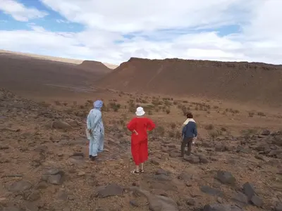 a group of three people standing in the desert at Titanic hôtel restaurant & désert excursions lac irik in Foum Zguid