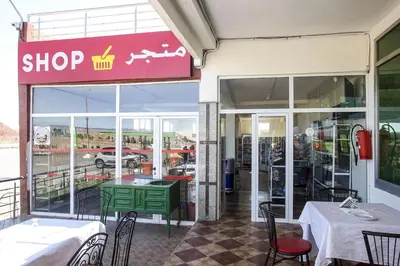 a restaurant with a green table in front of a window at HOTEL LA POMME ZAIDA in Zaida