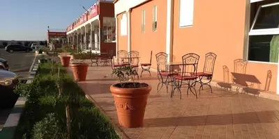 a patio with tables and chairs and a table and chairs at HOTEL LA POMME ZAIDA in Zaida