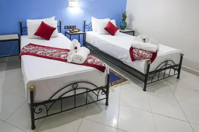 two beds with towels on them in a room at HOTEL LA POMME ZAIDA in Zaida