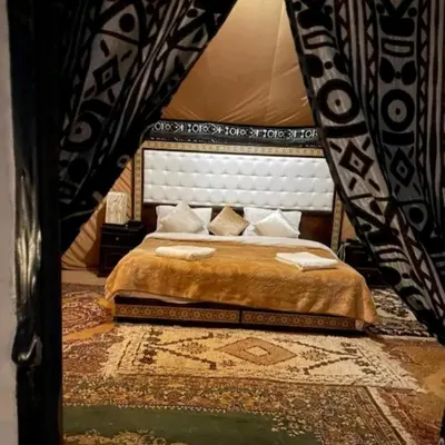 a bedroom with a king sized bed in a room at Local Luxury Camp in Merzouga