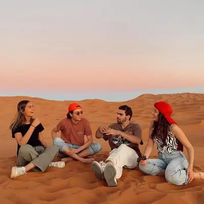 a group of people sitting in the desert at Local Luxury Camp in Merzouga
