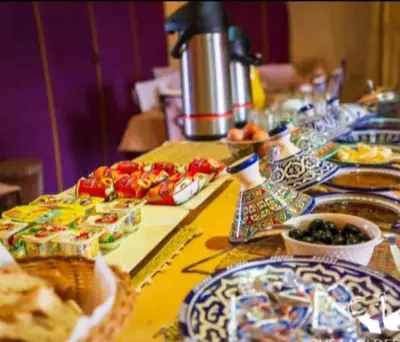 a long table with plates of food on it at Sahara Relax Camp in Merzouga