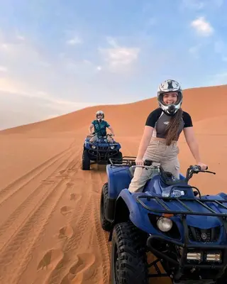two people riding on atvs in the desert at Sahara Relax Camp in Merzouga