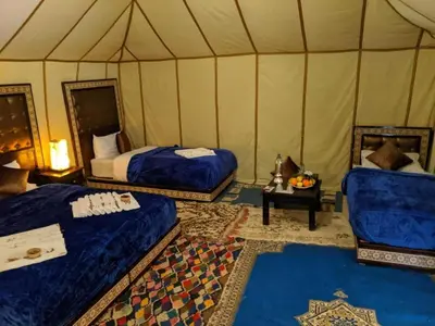 a bedroom with two beds in a tent at Sahara Relax Camp in Merzouga