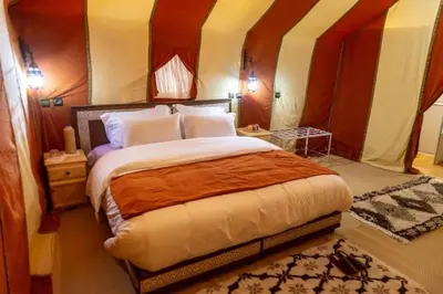 a bedroom with a large bed in a room at Sahara Relax Camp in Merzouga