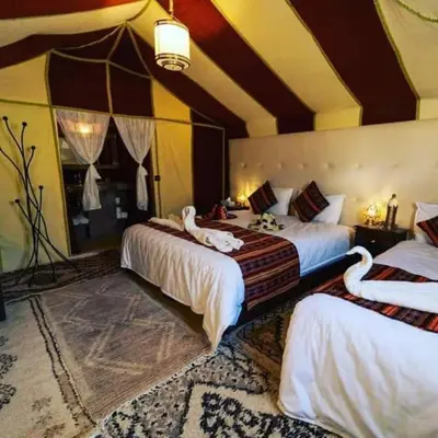 a bedroom with two beds with swans on them at Sahara Relax Camp in Merzouga