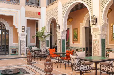 a courtyard with tables and chairs in a building at Dar Lys Luxury Riad & Spa in Fès