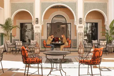 two people sitting at a table on a patio at Dar Lys Luxury Riad & Spa in Fès
